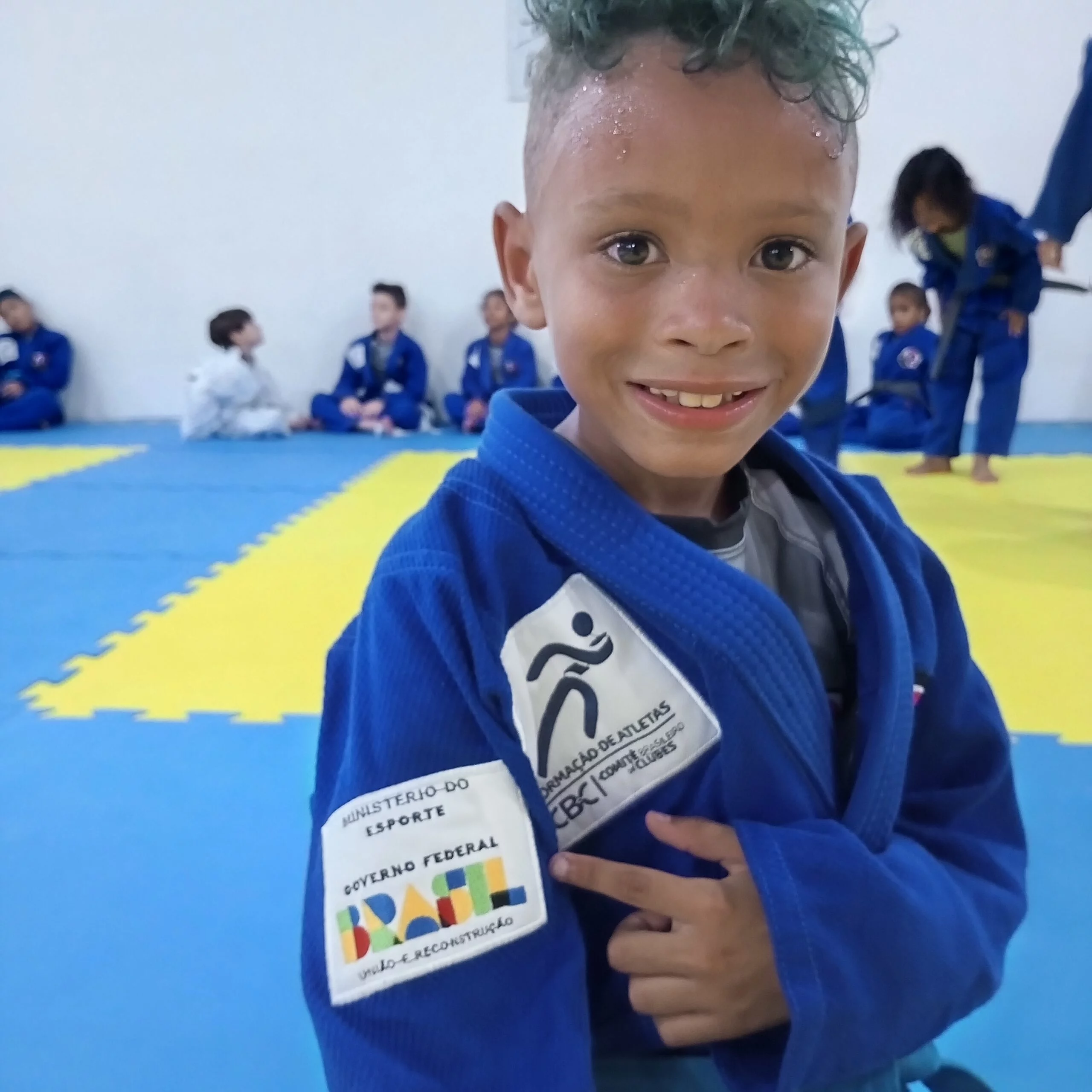 Criança com o kimono do samurais apontando para o braço